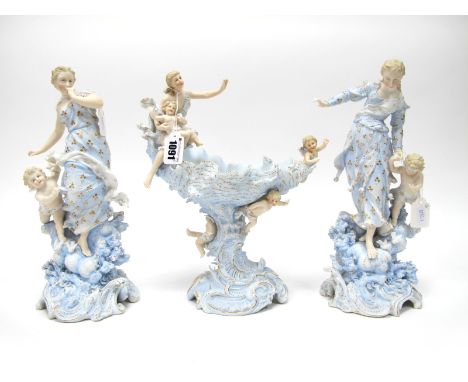 A Late XIX Century German Bisque Porcelain Figural Garniture, decorated in shades of blue and gilt, the central shell bowl ra