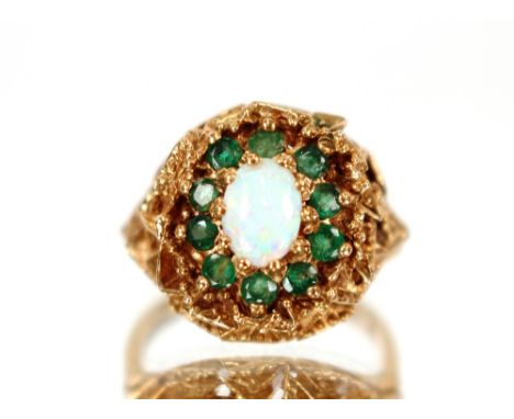 A 9ct gold ring,&nbsp;set with a central opal and surrounded by green stones, 5.5gms