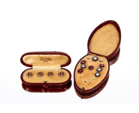 A leather cased set of four yellow metal&nbsp;and enamel&nbsp;decorated buttons;&nbsp;and an oval leather cased part set of b
