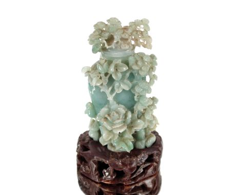 A jade vase and cover,&nbsp;of tree form with scrolling foliage, raised on hard wood plinth, height of vase 14cm