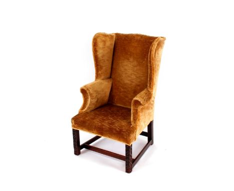 A 19th Century mahogany framed wing back armchair,&nbsp;in the Chippendale style, raised on square section front supports wit