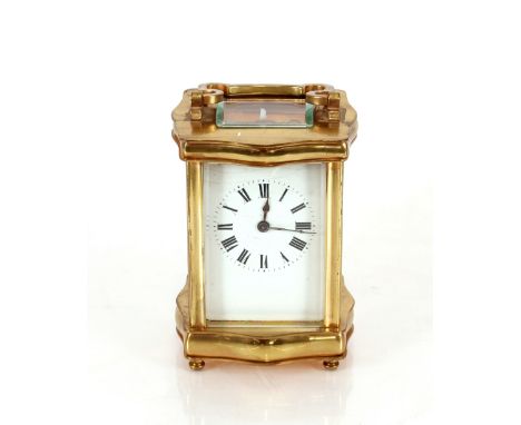 A brass cased carriage timepiece,&nbsp;in serpentine shaped case, white enamel Roman numeral dial complete with key, 15cm hig