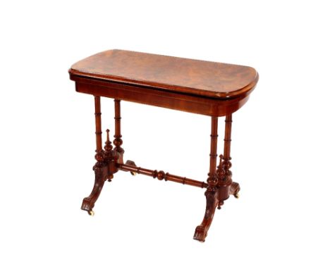 A Victorian burr walnut card table,&nbsp;with fold over swivel top, raised on turned columns terminating in scrolled feet and