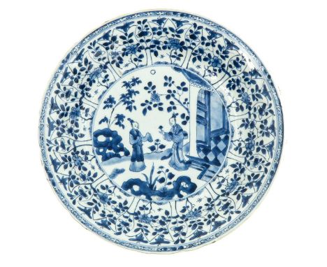 Kangxi Period, depicting gathering of Chinese figures in garden with floral decor border, 28 cm. in diameter, chip.