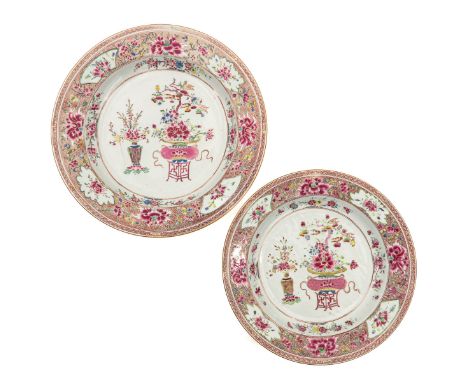 Decorated with a vase and a basin on stand filled with flowers, 18th Century, largest charger is 39 cm. in diameter, 