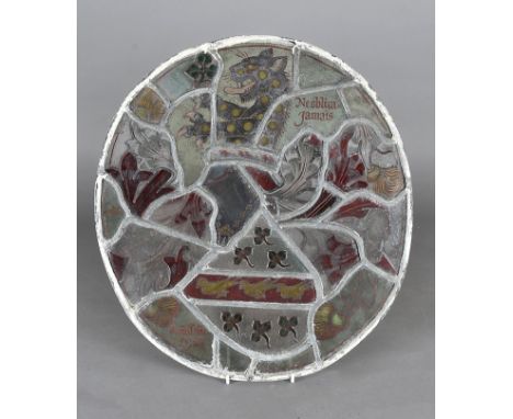 An oval stained glass panel, dated and signed 1921, depicting an Irish coat of arms with a knights helmet and leopard rampant