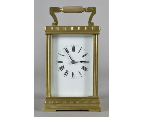 A brass carriage clock, in brass case with white enamel face and Roman numerals, 13 cm x 8 cm x 7 cm in an over sized leather