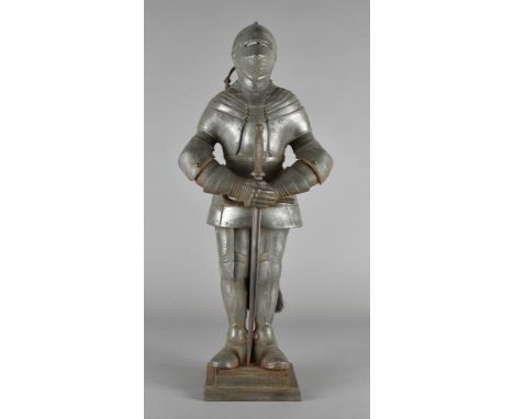 A cast iron companion set, modelled as a knights armour with sword poker and tools to reverse, registered design mark to base