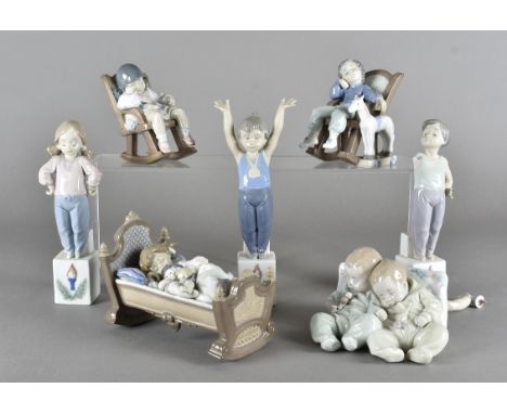 A collection of Lladro children figures, modelled sleeping, together with a set of three trophy figures (af) and others 
