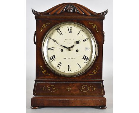 A William IV mahogany eight day mantel clock, with brass inlay, domed top with carved arch inlaid with brass, fret carved sid
