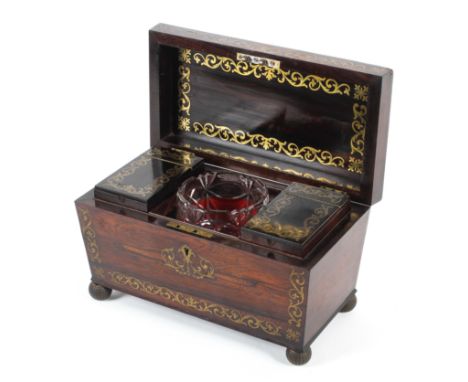 A Regency rosewood and brass inlaid sarcophagus shaped tea caddy. Inlaid to interior and exterior with brass foliate scrolls,