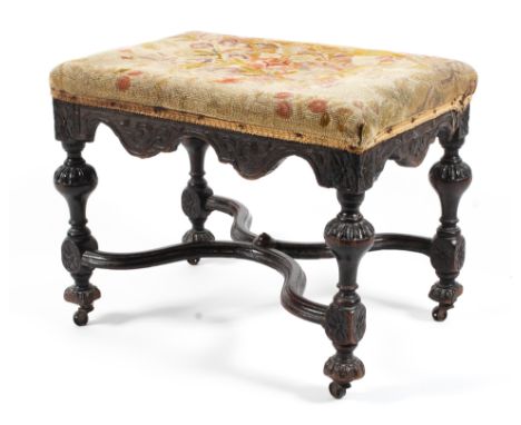A William and Mary carved mahogany footstool, late 17th century. With scroll aprons, on four gadrooned baluster legs carved w