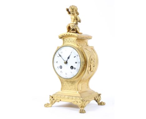 A 19th century gilt metal mantle clock. The enamel dial with Roman numerals denoting hours, with classical finial, raised on 