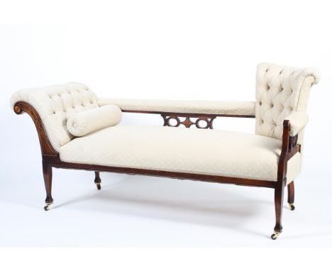 An Edwardian mahogany framed upholstered chaise longue. With button back and scroll rest, the back pierced with star and ovol