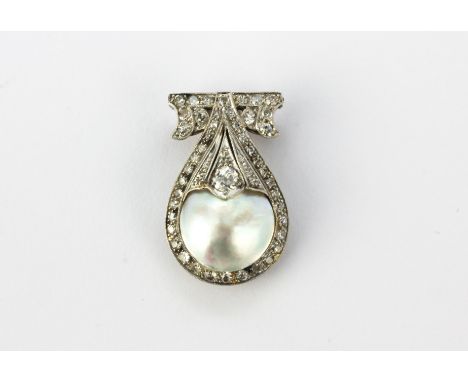 An antique c.1920's white metal (tested 18ct gold) clip/brooch set with a large Mabe pearl, approx. 12mm, and old cut diamond