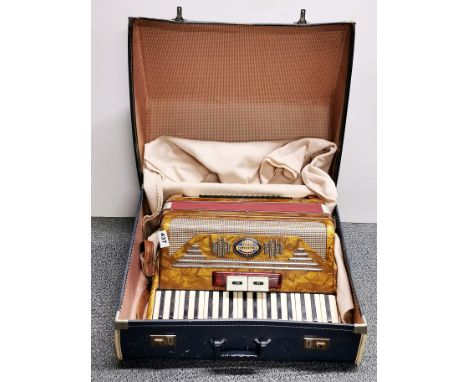 A cased Pigliacampo piano accordion.