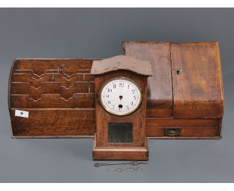 An oak stationery rack together with a mahogany stationary cabinet and a small mahogany mantle clock.