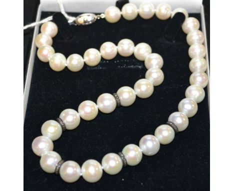 A cultured pearl and diamond beaded necklace, front section of creamy white cultured pearls, divided in to threes by five dia
