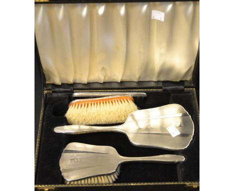 An early 20th century silver four piece dressing table set, mirror, comb and brushes, Birmingham marks, worn, cased, c.1925