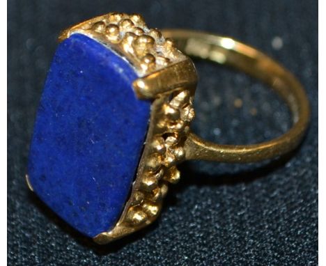 A lapis lazuli rectangular seal stamp panel ring, plain matrix, pierced basket collar, 18ct gold shank, stamped 750, 6.3g gro