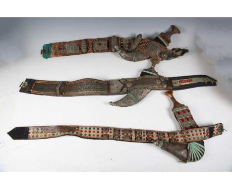 A group of three Middle Eastern jambiyas, each with typical curved blade, length of longest blade 23cm, with white metal moun