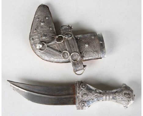 A mid-20th century white metal mounted jambiya with typical curved ribbed blade, blade length 13cm, and embossed sheet metal 