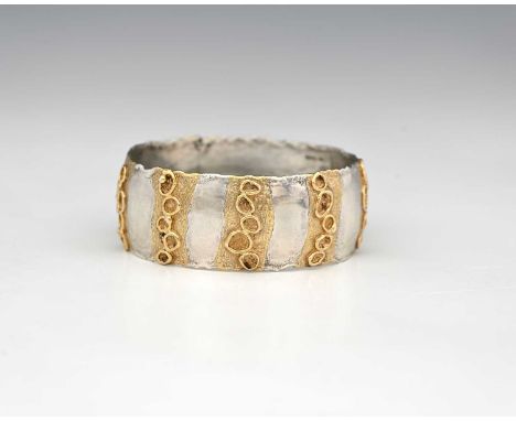 Jane Watling, a Modernist parcel gilt silver bangle, London 1990, irregular edged band form with striped of applied wire ring