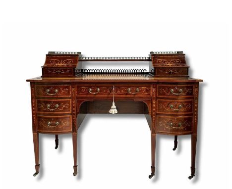 An Edwardian mahogany Carlton House desk, circa 1910, crossbanded, strung and marquetry inlaid throughout, gilt metal gallery