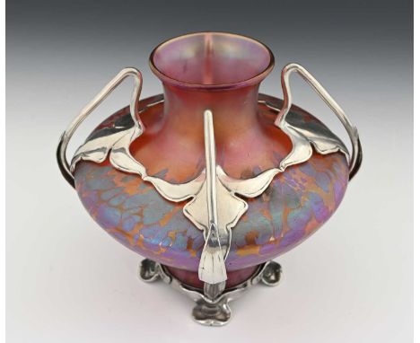 Loetz, a pewter mounted Secessionist iridescent glass vase, twin handled organic cage containing an amphoral form vase