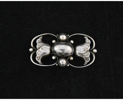 Georg Jensen, a Sknovirke silver brooch, model 236A, open scroll design with two flowers flanking a central oval cabochon and