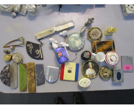 A mixed lot of items to include an inlaid white metal stick pin in a box, various compacts, combs to include a silver cased c