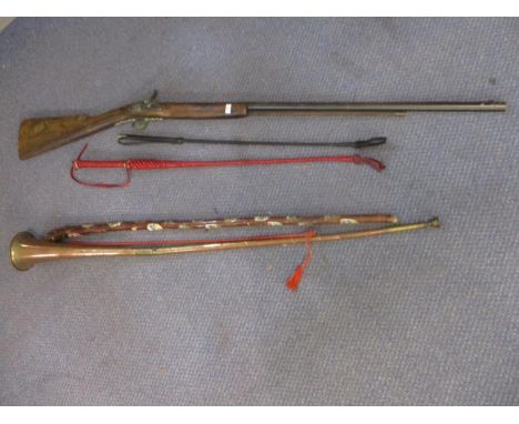 A reproduction musket, two whips, a continental walking stick and a post horn 