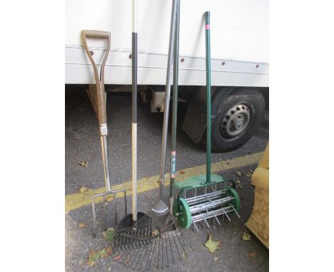 A selection of gardening tools to include a digging fork, a rake and other items 