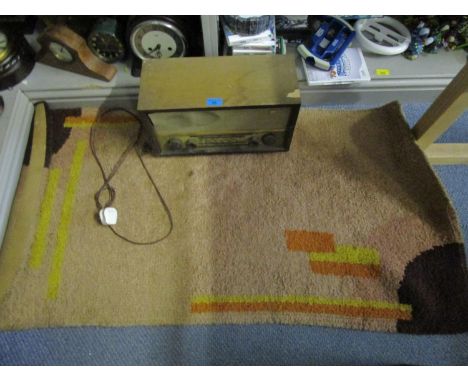 A Pam wood effect cased radio and a small fern coloured rug, along with an oriental metal thread embroidery of a peacock on a