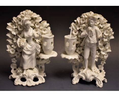 A pair of 19th century hard paste smokey glazed blanc de chine figural candlestick, in the manner of Plymouth, of a man and l