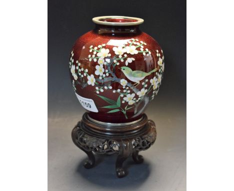 A Japanese cloisonné enamel ovoid vase, decorated in colourful polychrome with a finch on a branch of cherry blossom, garnet 