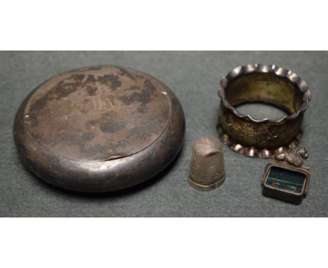 A silver circular snuff box; a silver napkjin ring, chased decoration; a bloodstone and carnelian swivel fob; a silver thimbl