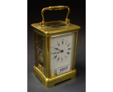 An early 20th century brass carriage clock, five bevelled glass panels, carrying handle