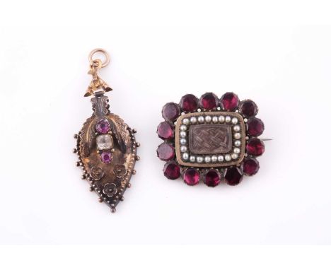A Victorian yellow gold, garnet, and pearl Momento Mori brooch, centred with a glass panel holding plaited hair, within a bor