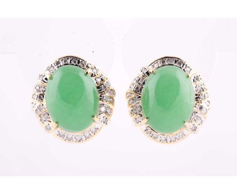 A pair of 18k yellow gold, jade, and diamond earrings, each set with an oval cabochon jade, within a border of round brillian