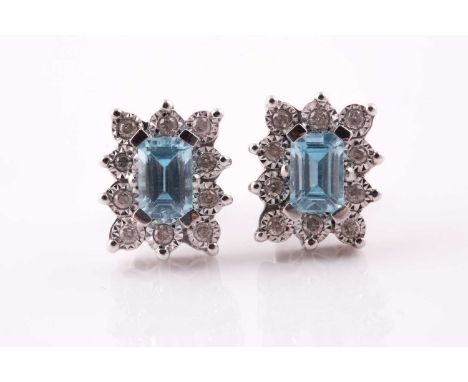 A pair of topaz and diamond cluster earnings; the rectangular step cut, cut-cornered topaz in four claw mount above a ten sto