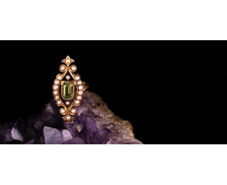 An antique peridot and pearl lozenge-shaped ring; the rectanguar cut cornered peridot in millegrain mount within an open scro