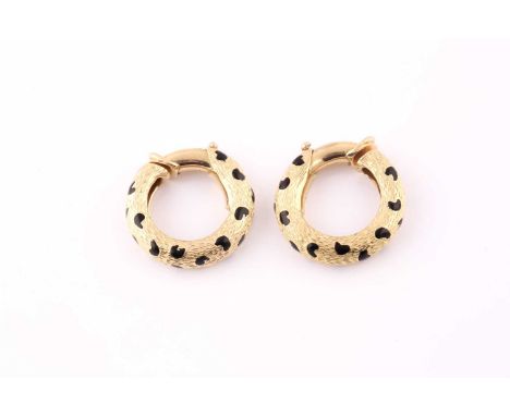 A pair of Kutchinsky 18 carat gold and enamel leopard spot hoop earrings; the tapering, textured hoops with hinged fittings o