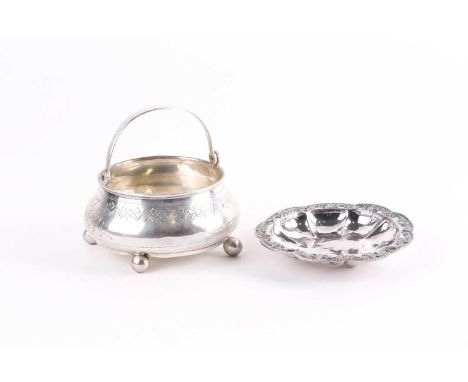 A late 19th century Russian silver swing-handle bowl, with engraved foliate and geometric motif decoration, on three ball fee