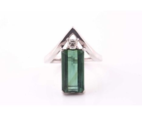 A diamond and chrome tourmaline dress ring; the elongated step cut tourmaline in four claw setting with Asscher cut diamond s