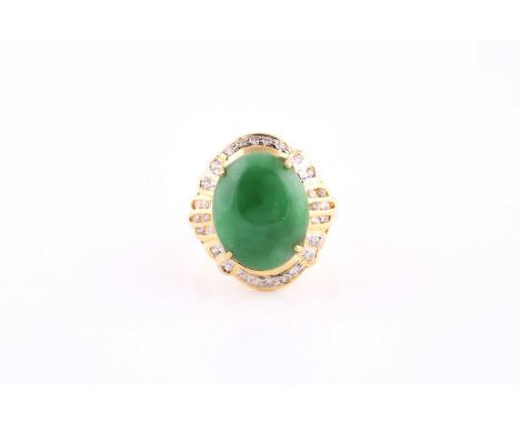 An 18ct yellow gold, diamond, and jade ring, set with an oval cabochon jade plaque, within a fancy border of round brilliant-