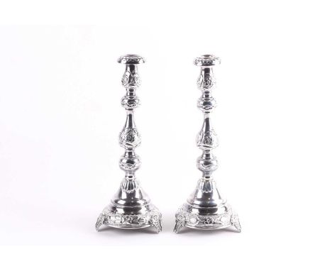 A pair of early 20th-century silver table candlesticks, London 1916 by Joseph Zweig. The hollow bodies with repouse decoratio