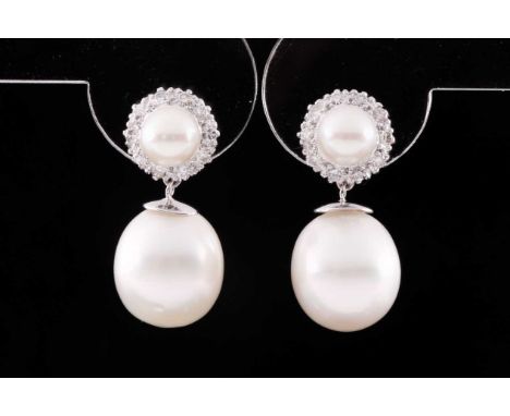 A pair of diamond and pearl drop earrings, each with a cultured pearl within a border of round-cut diamonds, suspended with S