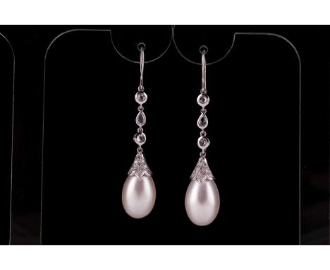A pair of diamond and pearl drop earrings, white metal hooks, suspended with three bezel-set rose-cut diamonds, with diamond 