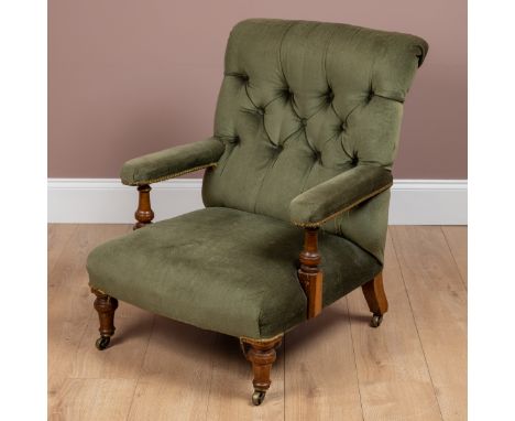 On shortened legs with a button back and walnut frame.63cm wide x 84cm highSome signs of damage to the arm supports, some min